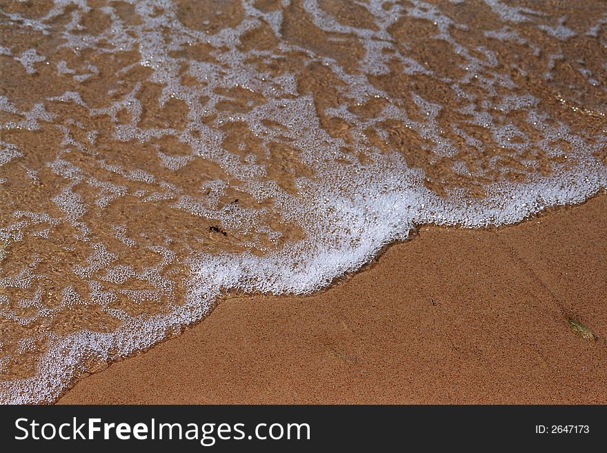 The foamy wave washes sand coast. The foamy wave washes sand coast