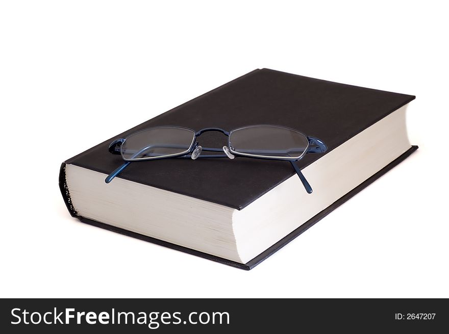 Eyeglasses on book isolated on white