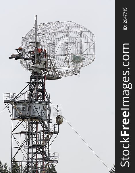 Middle distance view of a radar dish gleaming silver in the hazy light of the afternoon sun. Middle distance view of a radar dish gleaming silver in the hazy light of the afternoon sun