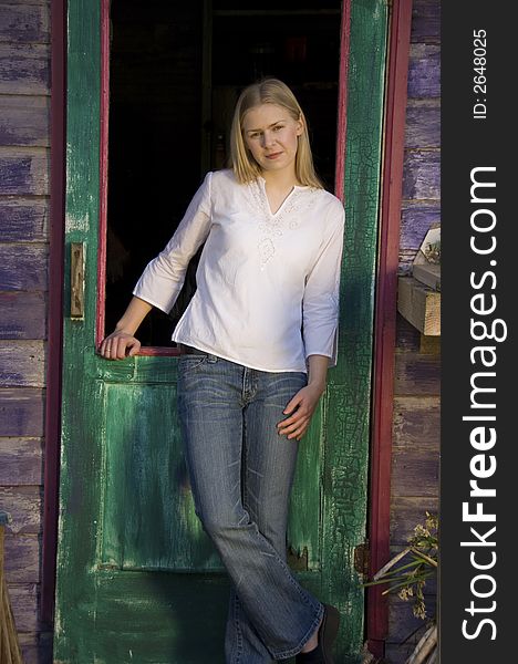 Blond girl in rustic doorway