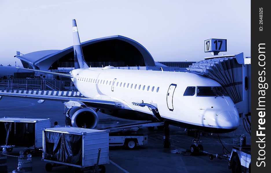 Plane ready for departure, early morning flight. Blue monochrome