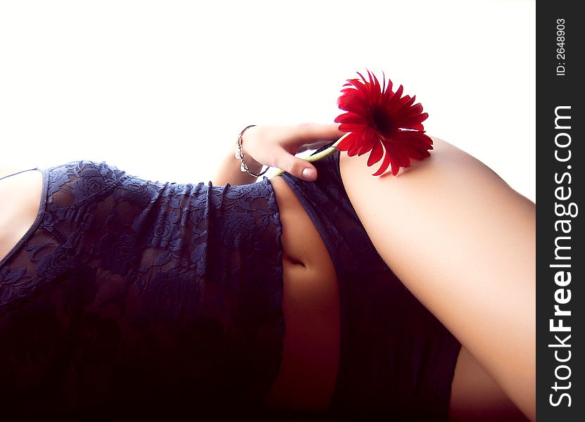 A girl lying on one side whith a red flower. A girl lying on one side whith a red flower