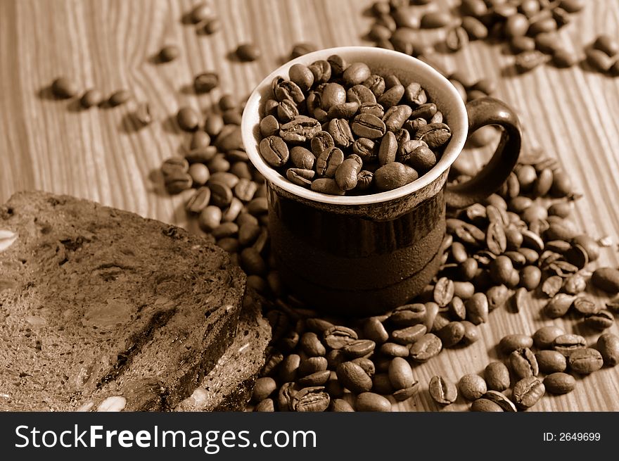 Coffee beans and rye toast on tabletop. Coffee beans and rye toast on tabletop