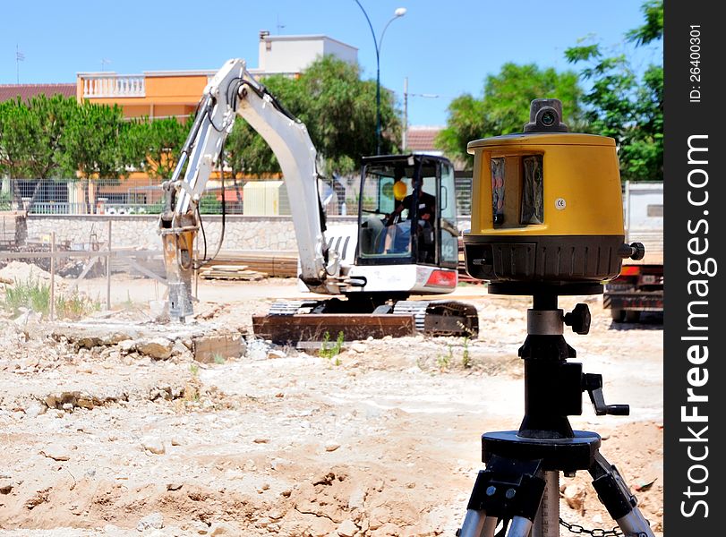 Excavator with hammer demolishes concrete structure for the foundation of new building. Operate with laser. Excavator with hammer demolishes concrete structure for the foundation of new building. Operate with laser