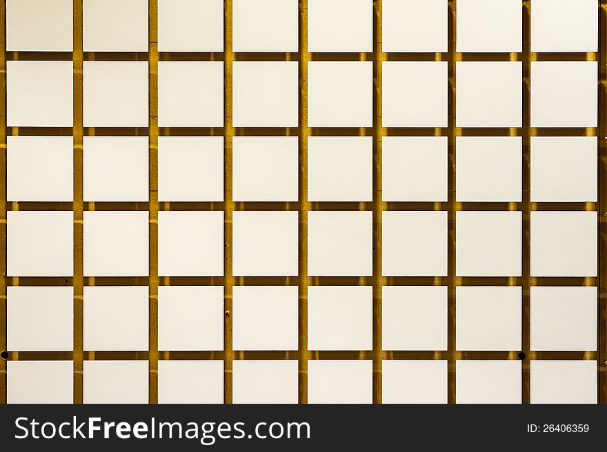Wall of small squares raised off a yellow backdrop. Wall of small squares raised off a yellow backdrop.