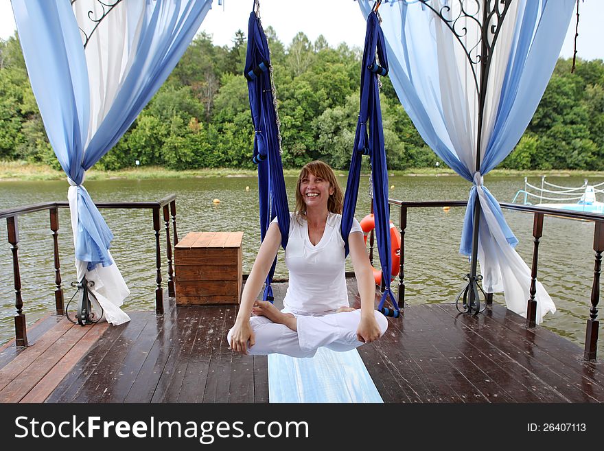 Female aerial yoga relaxing in a hammock