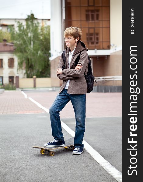 School teen with schoolbag and skateboard, day