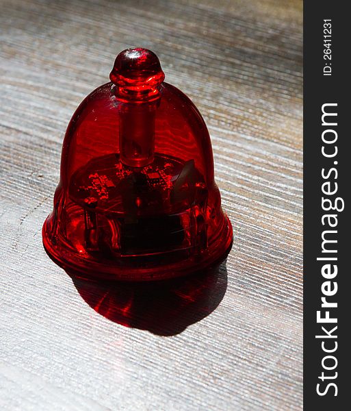 Red call-bell for a waiter on a wooden table. macro