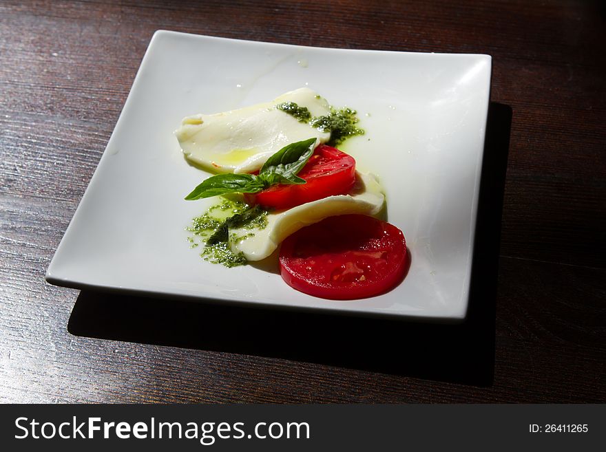 Cheese and tomatoes on a plate in cafe. Cheese and tomatoes on a plate in cafe