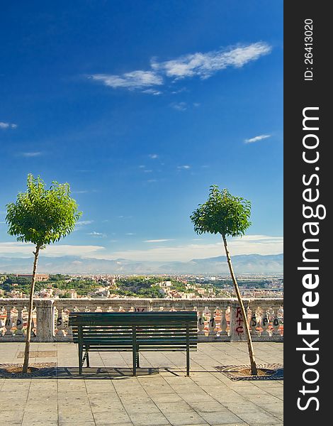 An iron bench and two trees on Vomero hill with view over Naples, Italy. An iron bench and two trees on Vomero hill with view over Naples, Italy