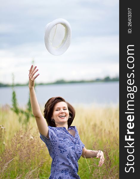 Happy young woman throwing her hat in the air. Happy young woman throwing her hat in the air