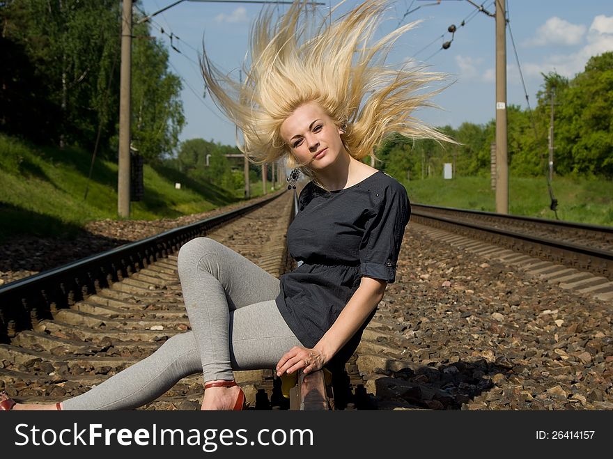 Girl blonde sitting on the rails