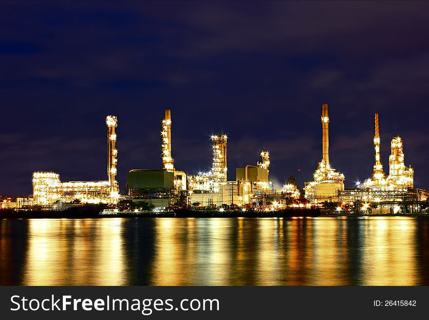 Oil refinery factory with reflection on the river.