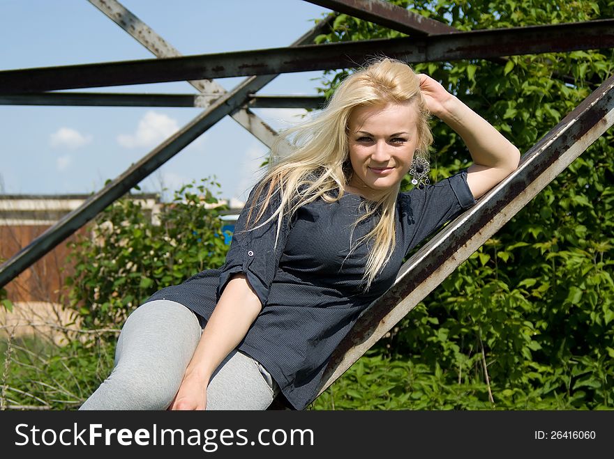 Beautiful blonde girl lies on a construction site on the nature