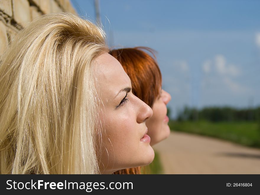 Two Girls Stand At The Wall