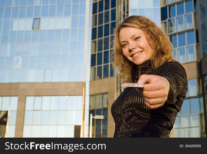 Woman giving credit card, or doing shopping and paying opposite office building