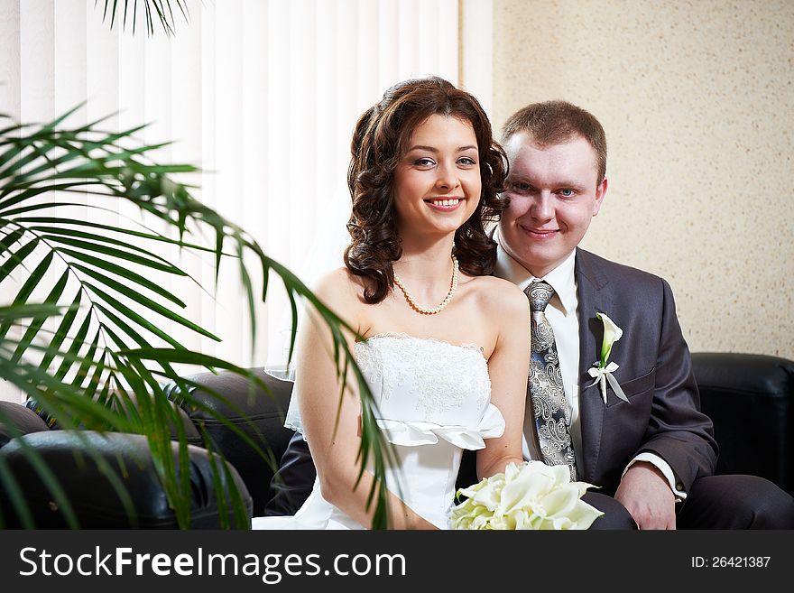 Happy bride and groom sitting together