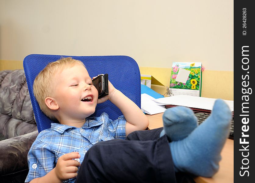 Small cute business boy with phone  in office