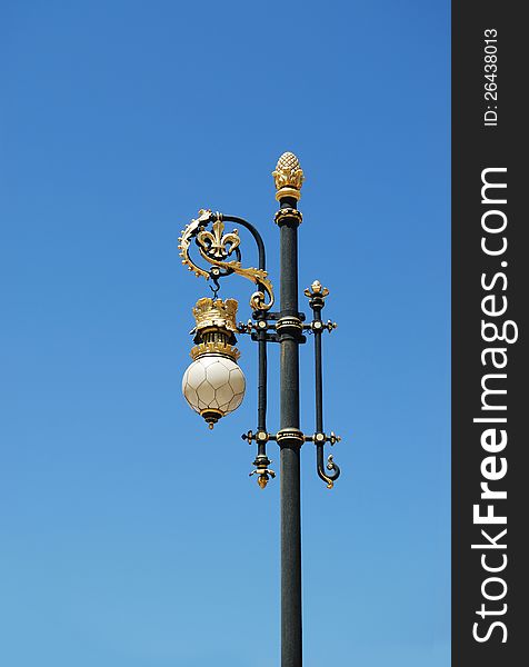 Gold and black street lamp on blue sky. Gold and black street lamp on blue sky