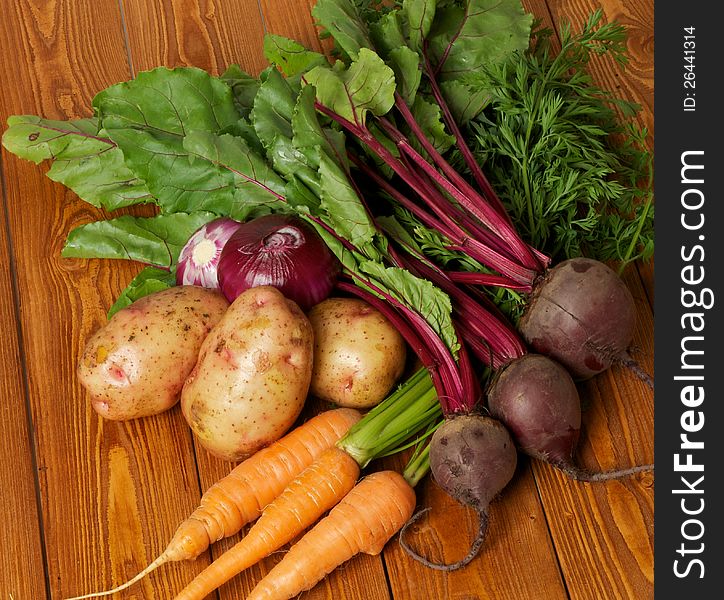 Heap of Raw Organic Potato, Carrot, Red Onion and Beet close up on wooden background. Heap of Raw Organic Potato, Carrot, Red Onion and Beet close up on wooden background