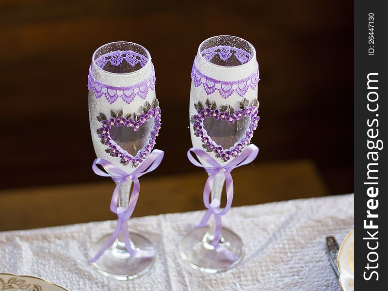 Couple of wedding glasses with flower, hearts and ribbon as love symbol for valentine day. Marriage photo background.