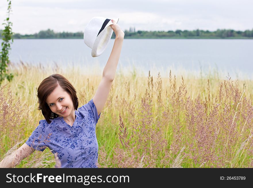 Slim shaped girl enjoying nature in the meadow by the lake