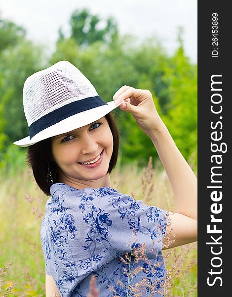 Laughing girl in white straw hat on the meadow. Laughing girl in white straw hat on the meadow