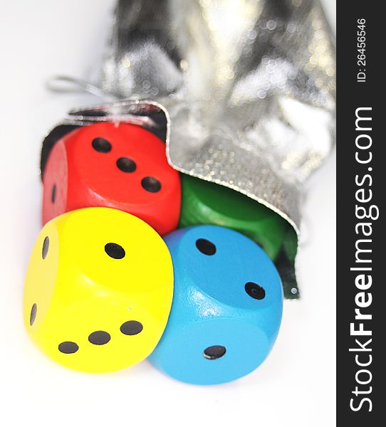 Wooden multicolor dice getting out from silver sack. Wooden multicolor dice getting out from silver sack