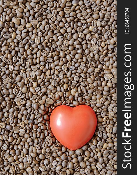 Detailed roasted coffee beans background with red heart symbol on it. Detailed roasted coffee beans background with red heart symbol on it