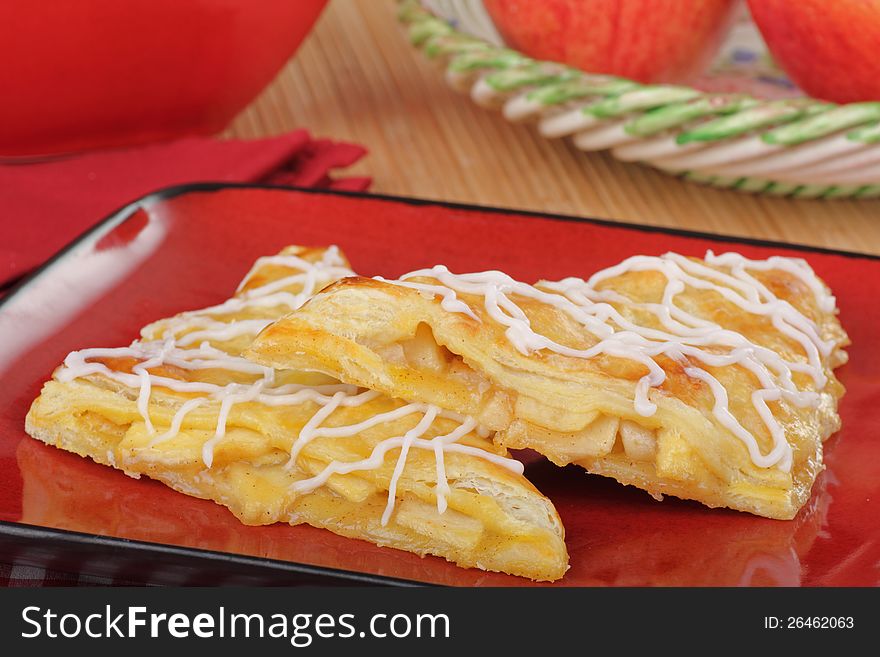 Two apple turnovers on a red plate