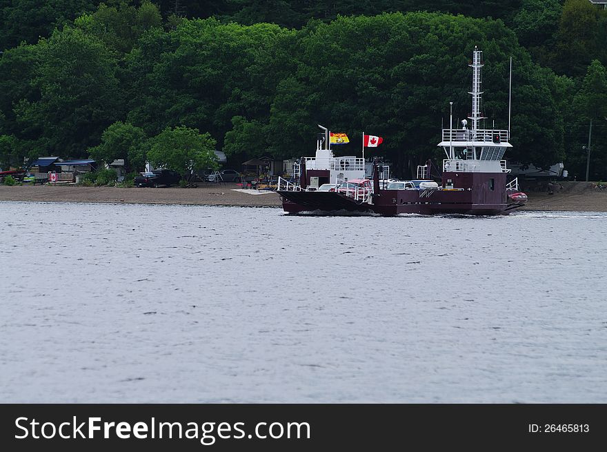 A river car ferry bring a load across the river. A river car ferry bring a load across the river