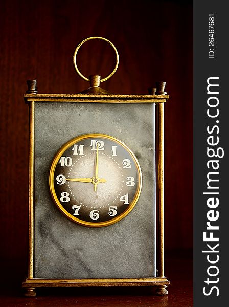 Face of an antique marble clock on a old wooden background