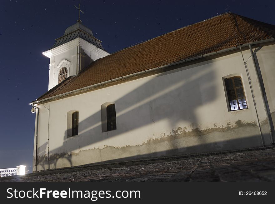 Night shot of the little church in Vrsac (small town in Srbija) with a bench reflection and stars above. Night shot of the little church in Vrsac (small town in Srbija) with a bench reflection and stars above.