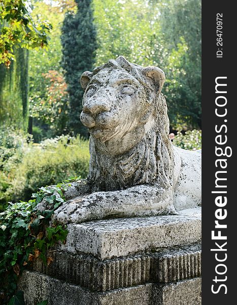 Stone sculpture of lion in green park area. Stone sculpture of lion in green park area