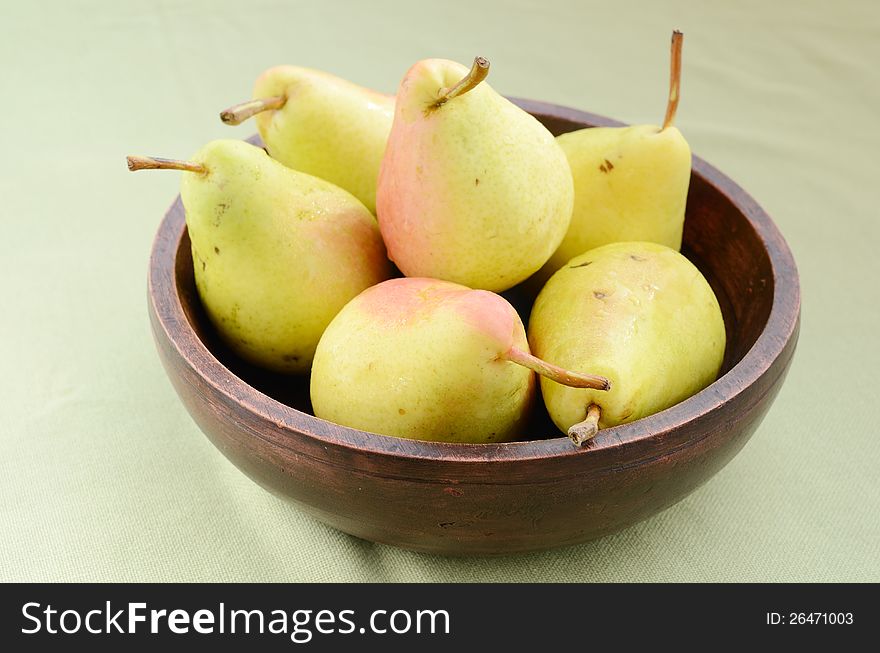 Yellow pears in old wooden bowl