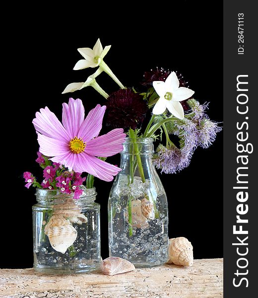 A Simple Arrangement of Flowers in a Jar and Bottle. A Simple Arrangement of Flowers in a Jar and Bottle