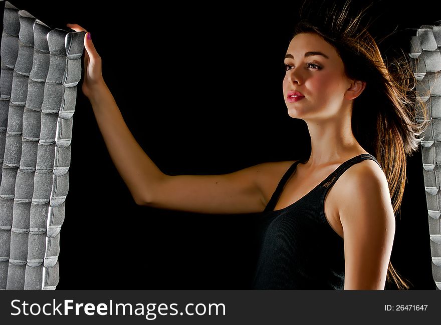 A beautiful teenage girl with smooth complexion places her hand on a nearby soft box as she looks off into the distance and the lights hit her hair as it blows in the wind. A beautiful teenage girl with smooth complexion places her hand on a nearby soft box as she looks off into the distance and the lights hit her hair as it blows in the wind.