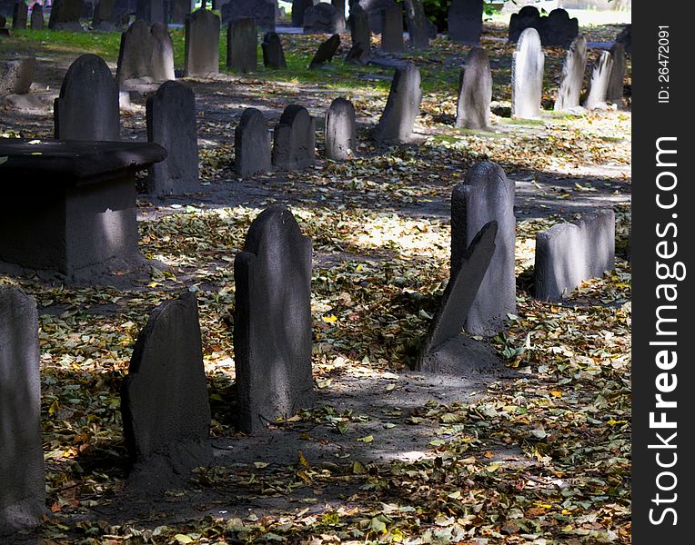 Old headstones in a graveyard with leaves on the ground