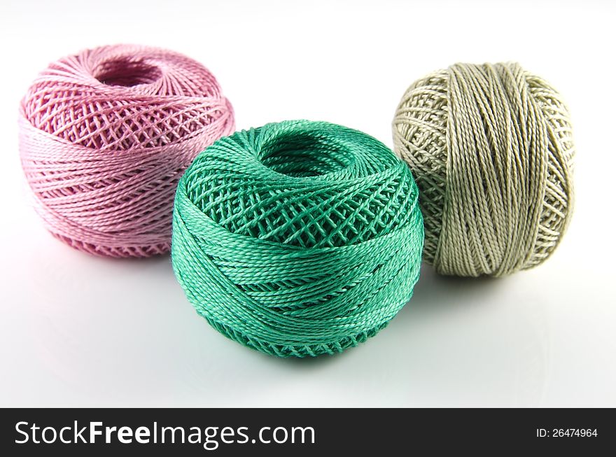 A picture of some balls of thread ,isolated on white background, all very useful for sewing.