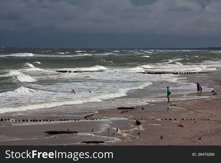 Lonely man stands on the beach looks towards sea weaves. Lonely man stands on the beach looks towards sea weaves