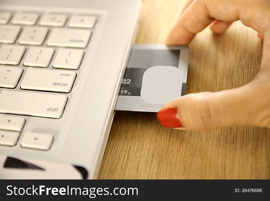 Credit card insert inside laptop on the wooden desk