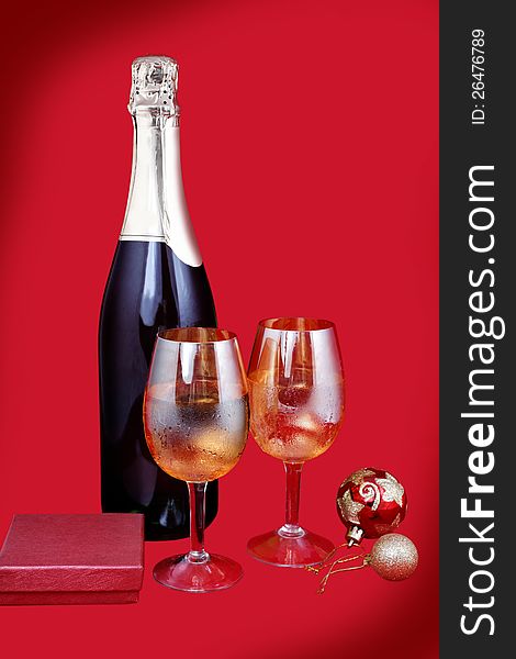 Glasses with champagne and gifts red background