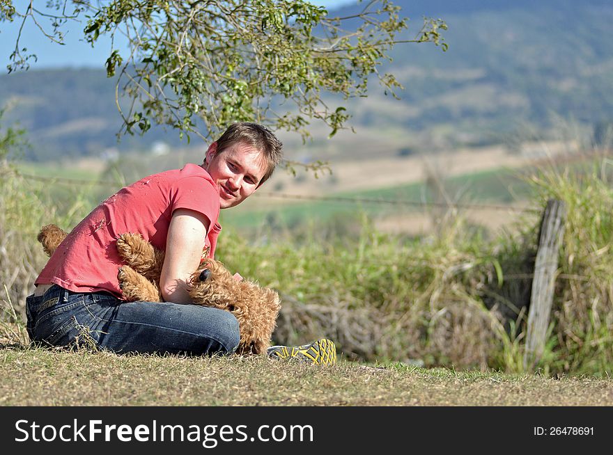 Young man playing with dog in countryside