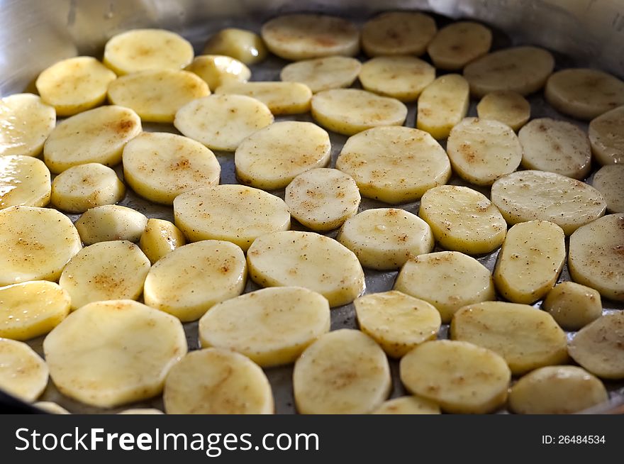 Sliced potatoes in a cooking pan that are being cooked. Sliced potatoes in a cooking pan that are being cooked
