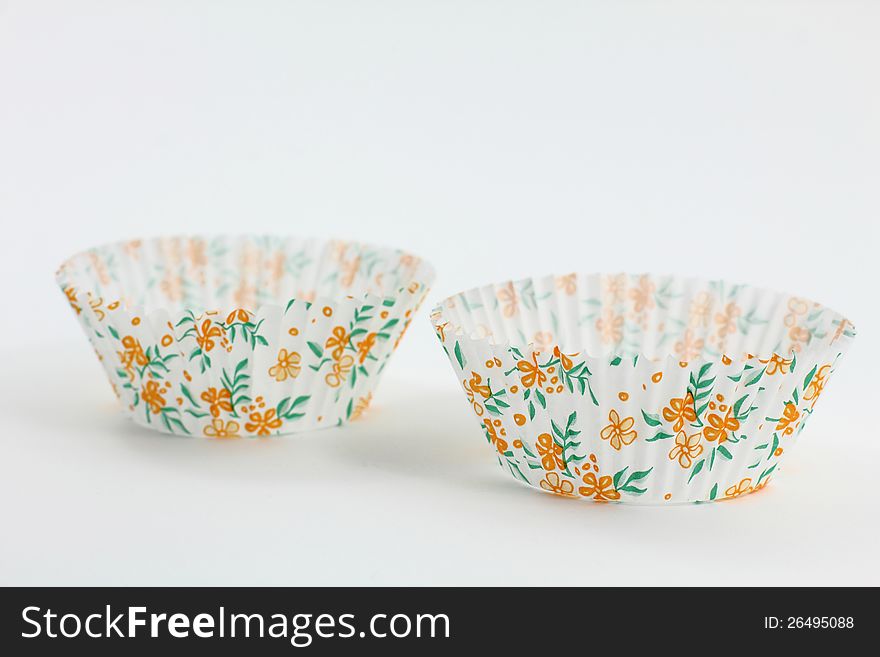 Two Flower-Themed Cup Cake Papers against a white backdrop.