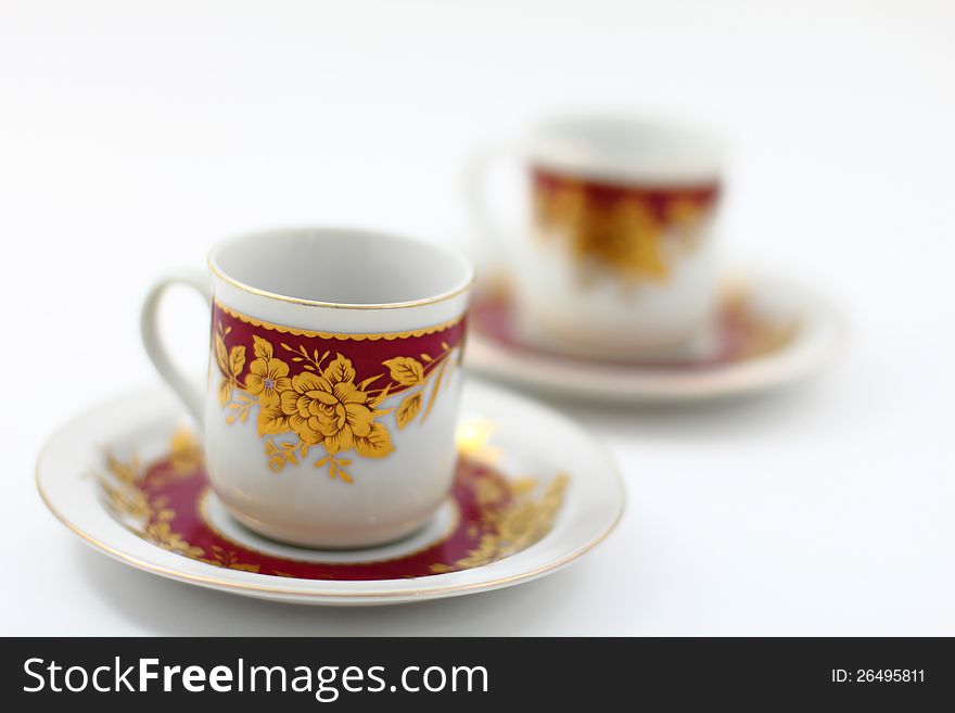 Two Traditional Arabic Coffee Cups against a white backdrop. The photo showcases the traditional cup and platter combination.