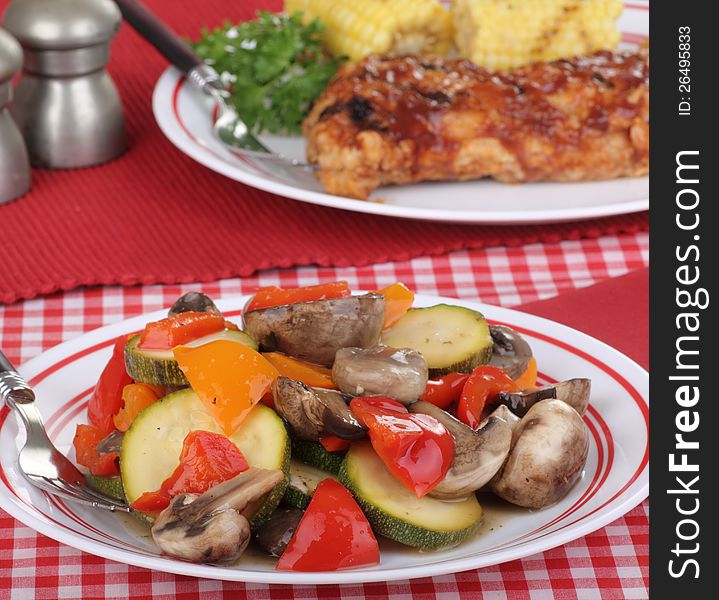 Cooked vegetables with red and orange peppers, zucchini, and mushrooms. Cooked vegetables with red and orange peppers, zucchini, and mushrooms