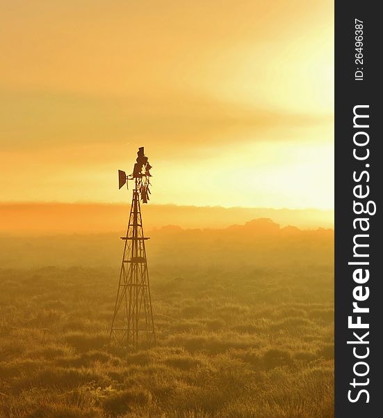 Landscape with Windmill water pump at sunrise