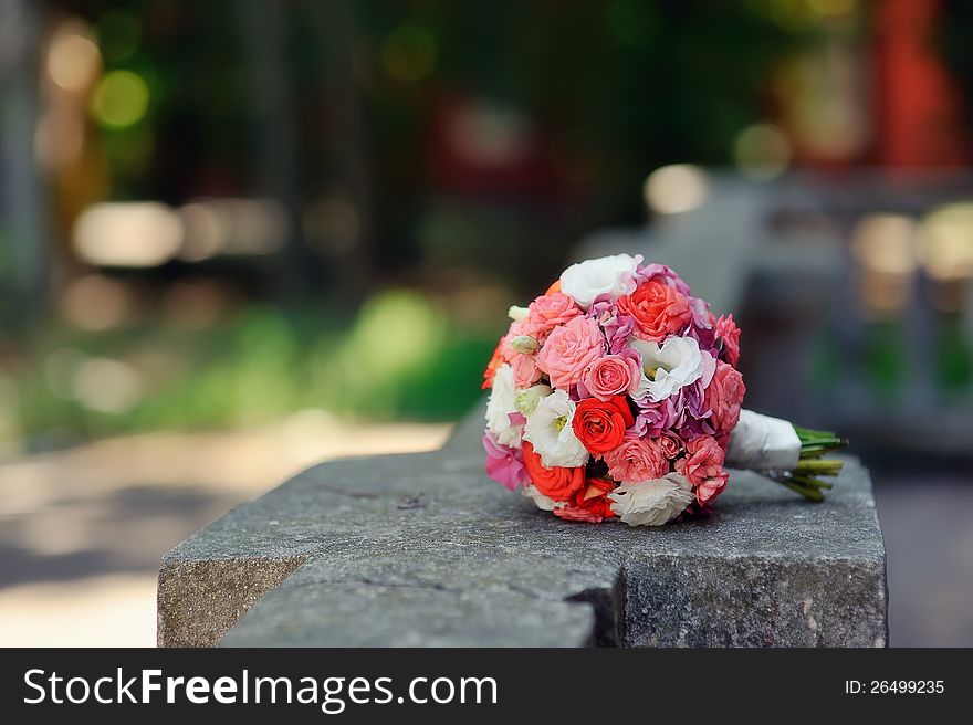 On the stone fence is a bouquet of roses for the bride. On the stone fence is a bouquet of roses for the bride