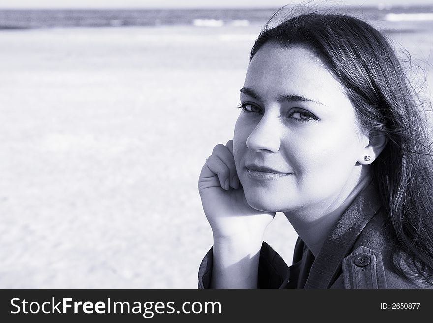 Beautiful woman with long dark hair and soft smile on beach. ISO 100, no sharpening, blue sepia. Beautiful woman with long dark hair and soft smile on beach. ISO 100, no sharpening, blue sepia